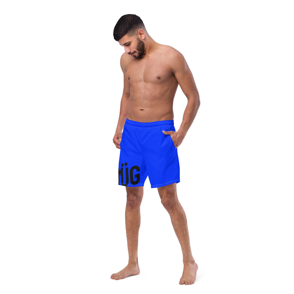 Man wearing blue swim shorts with a logo on a white background